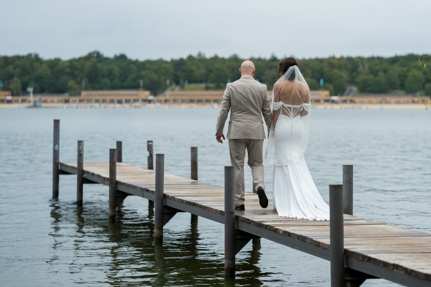 Brautpaar geht über einen Steg am See – Hochzeitsfotografin Elisa, Berlin & Brandenburg